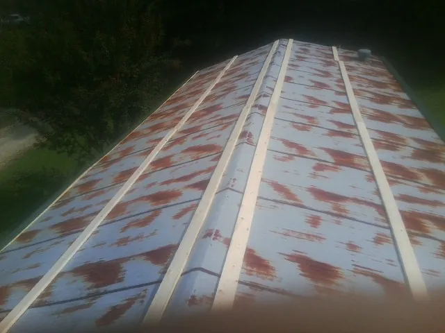 Rusted metal roof panels with new wood purlins before replacement — Storm Damage Roof Repair in Queensbury by Roofing Brothers