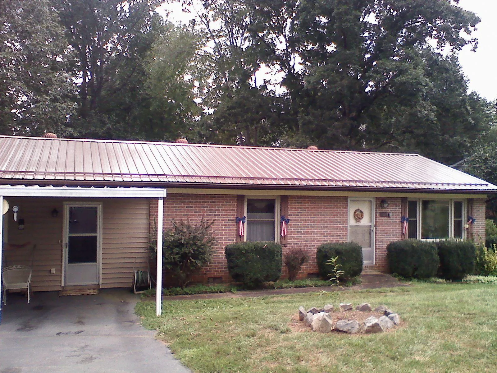 Bronze metal roof and carport on a brick ranch home — Roof Repair work by our crew in Queensbury